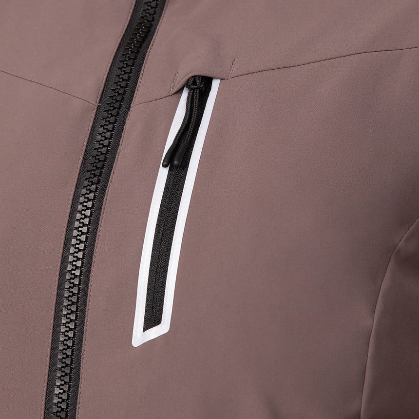 Woman wearing Free Country Women's FreeCycle® Thermo Super Softshell® II Jacket in light brown with a full front zipper opening, lower pockets, soft lining, a detachable hood with an adjustable drawcord, and water resistant and wind resistant stretch performance fabric, light grey background. Best women’s jacket for winter weather.