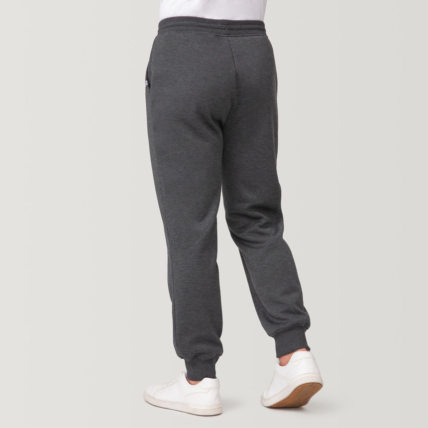 A man models Free Country Men’s Sherpa Lined Jogger in dark gray with white sneakers, showing the back view against a plain light background—ideal for cozy athleisure wear.