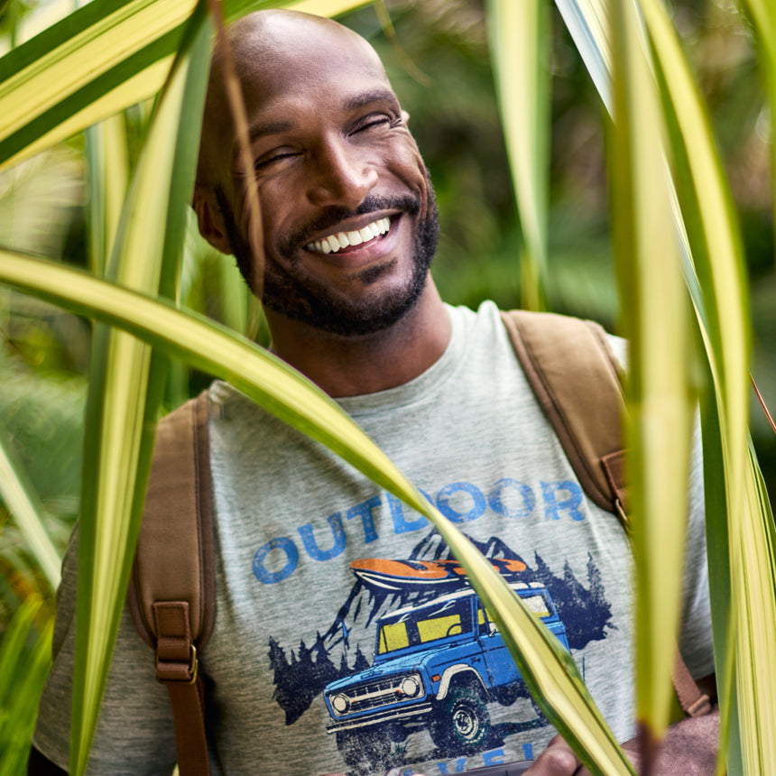 Man wearing Free Country Men's Super Soft Short Sleeve Crew Tee - 2 Pack in Basil, size M, made from anti-odor, breathable lightweight performance fabric featuring a classic active fit, an outdoor traveler design, and a peached finish #color_basil