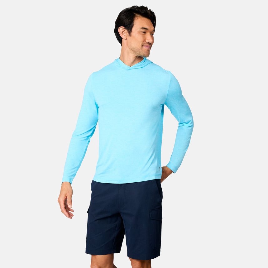 A man models the Free Country Men's Microtech® Hooded Graphic Sunshirt in light blue and dark navy cargo shorts against a plain white background, looking left with a slight smile.