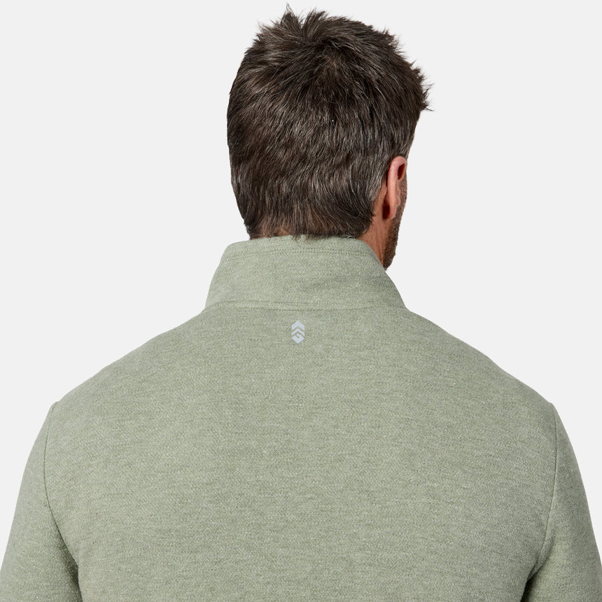 A man with short brown hair is shown from behind, wearing the Free Country Men’s Twill Interlock 1/4 Zip Long Sleeve Shirt in light olive green, featuring a breathable knit fabric and a small white logo on the upper back.