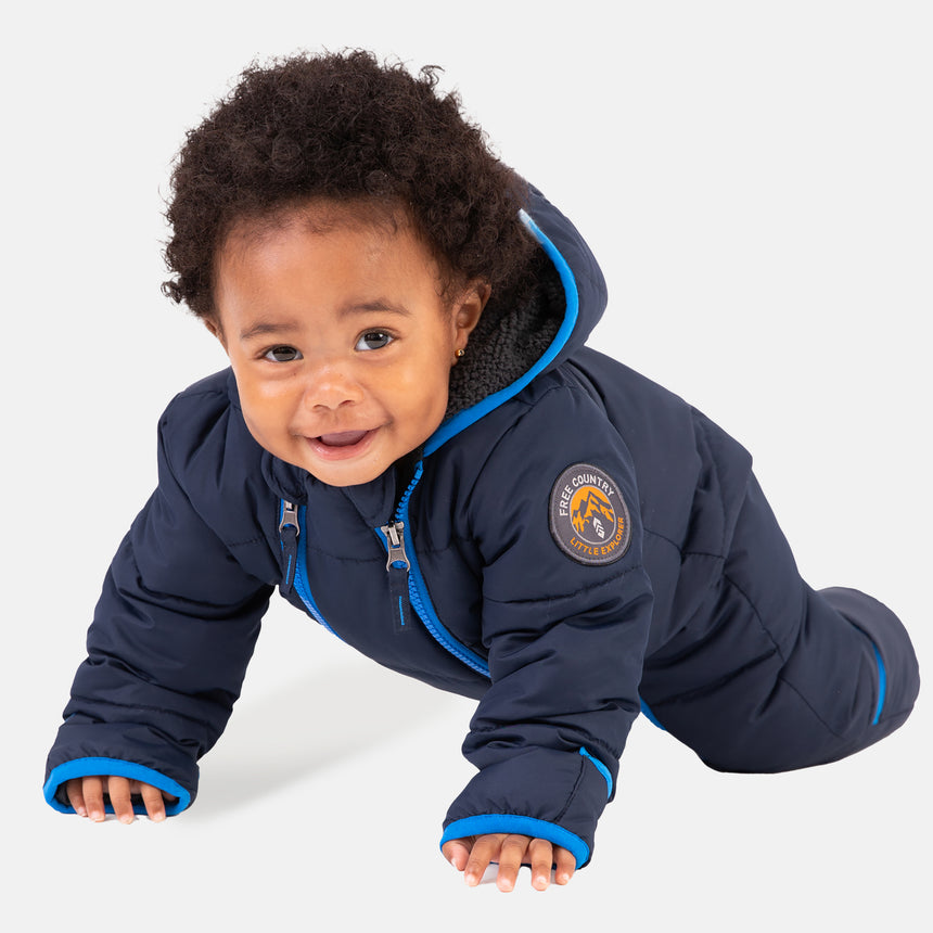 Free Country Kids' Infant Lightweight Quilted Puffer Snow Suit in navy, featuring wide channel quilting, sherpa lining, dual zippers, and fold-over mittens and booties for warmth and easy dressing.