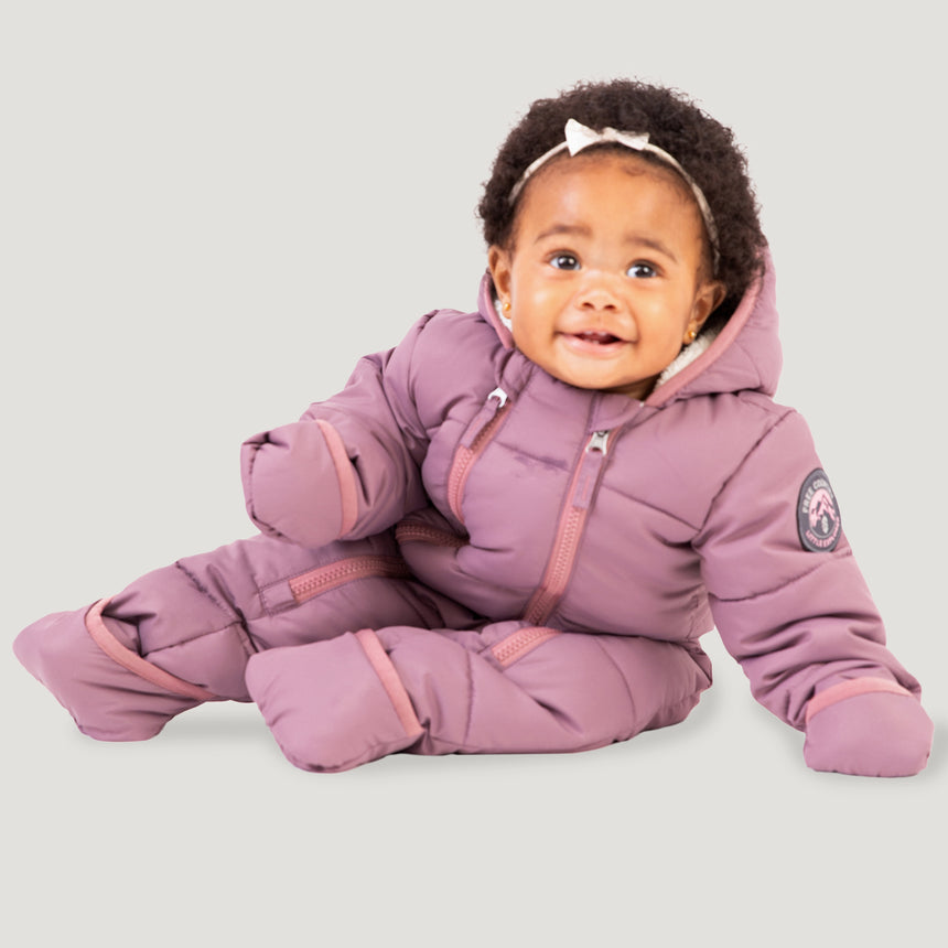Free Country Kids' Infant Lightweight Quilted Puffer Snow Suit in light purple, featuring wide channel quilting, sherpa lining, dual zippers, and fold-over mittens and booties for warmth and easy dressing.