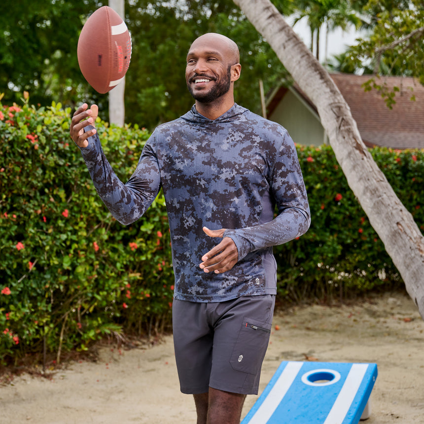 Man wearing Free Country Men's Tech Stretch Short II in Charcoal, size M, made from moisture wicking stretch performance fabric featuring an elastic waistband with a drawcord and a side slant pockets, styled with a charcoal upf hoodie #color_charcoal