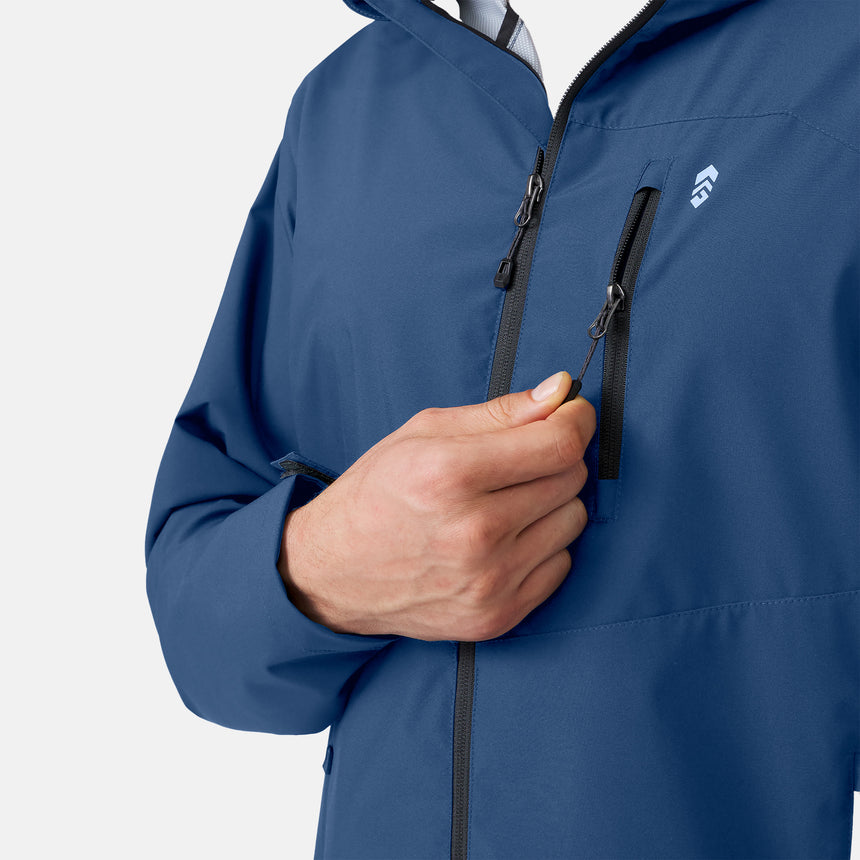 A person in a Clearance Men’s Hydro Lite X2O Highline Waterproof Jacket in blue pulls the zipper on a chest pocket. Only the torso and right hand are shown.