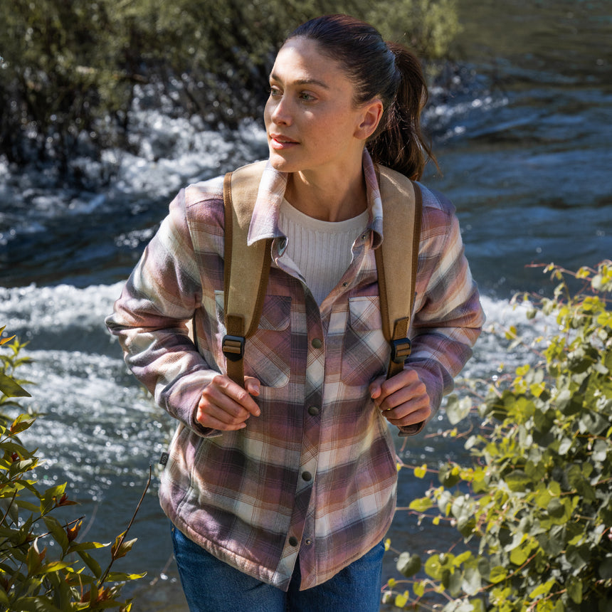 Woman wearing Free Country Women's Koshi Adirondack Flannel Shirt Jacket in pink and blue and white plaid with a full front button opening, soft lining, chest pockets, light grey background. Best women’s jacket for winter weather.