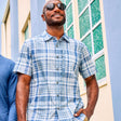 Man wearing the Free Country Men's Excursion Short Sleeve Poplin Shirt in Denim Plaid, size M, made from lightweight moisture wicking polyester fabric featuring vent at the back, full button down front, and a stand collar #color_ denim-plaid