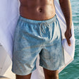 Man wearing Free Country Men's Palm Heaven Swim Short in Basil Plam Heaven, size M, made from lightweight stretch recycled polyester performance fabric featuring a full elastic waistband with a drawcord, UPF and quick dry technology, and side seam pockets #color_basil-palm-heaven