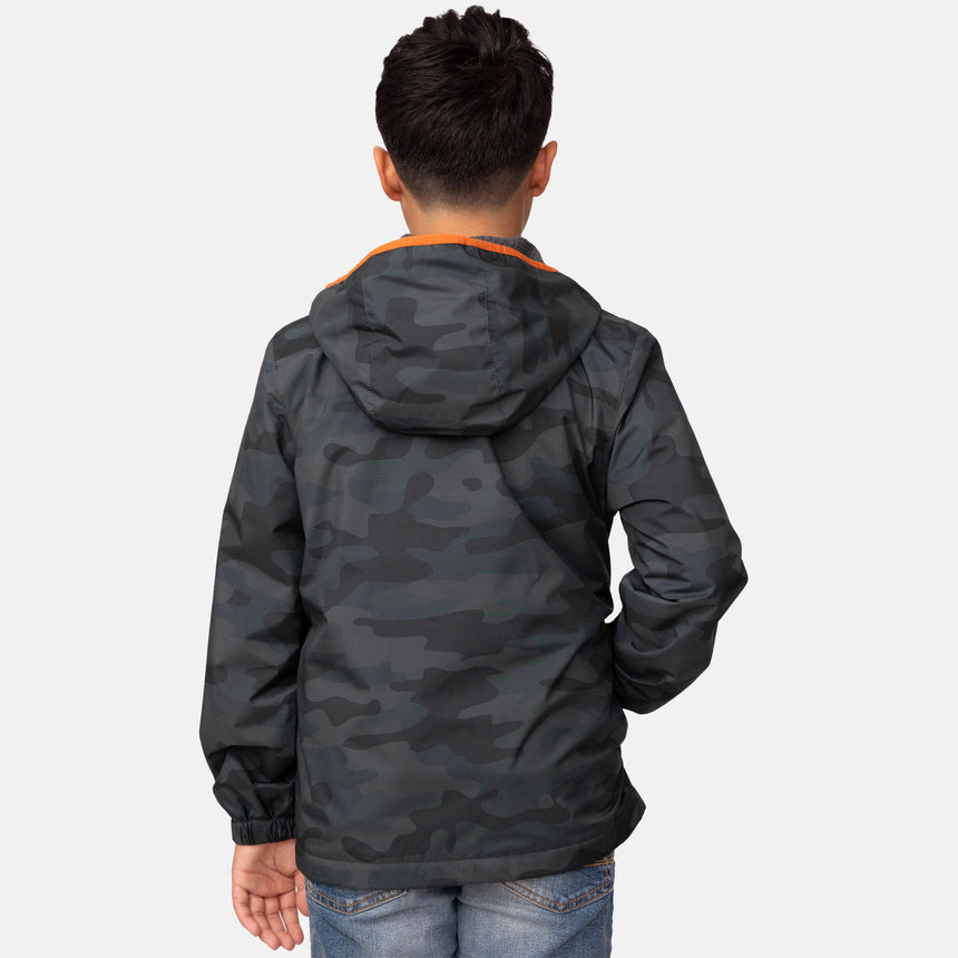 A child with short dark hair, seen from behind, wears the Clearance Boys' Brisk Walk Windshear Jacket in camo print with orange trim and light blue jeans, standing against a plain white background.