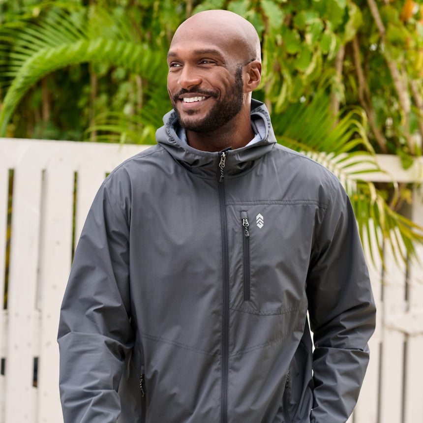 Man wearing the Free Country Men's Agile II Windshear Jacket in size M, made from lightweight wind and water resistant recycled polyester fabric and featuring an attached hood, inner phone pocket and elastic cuffs