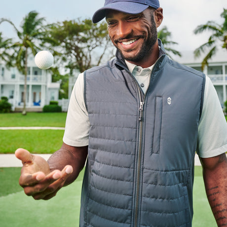 Man wearing Free Country Men's High Stretch Full Zip Vest in Coal, size M, made from lightweight water-resistant performance polyester fabric featuring a classic fit with lower pockets and a full length zip, worn over a white button down #color_coal