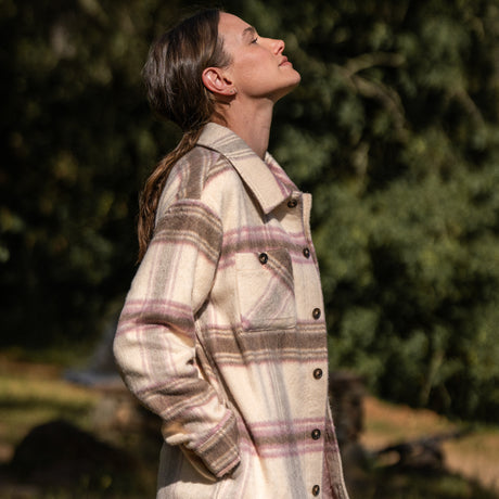Woman wearing Free Country Women's Hayley Plaid Shacket in pink and brown plaid with a full front button opening, chest pockets, light grey background. Best women’s jacket for fall weather.