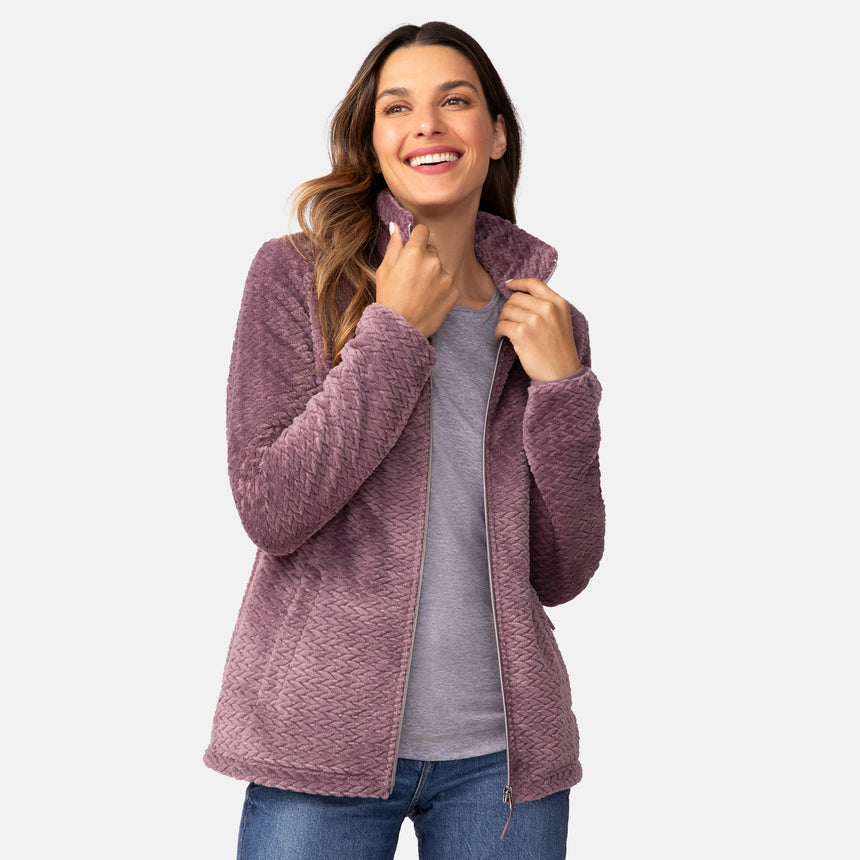 A smiling woman wearing a super soft, cable-braid textured Women’s Cable Braided Butter Pile® Jacket over a grey t-shirt and blue jeans.