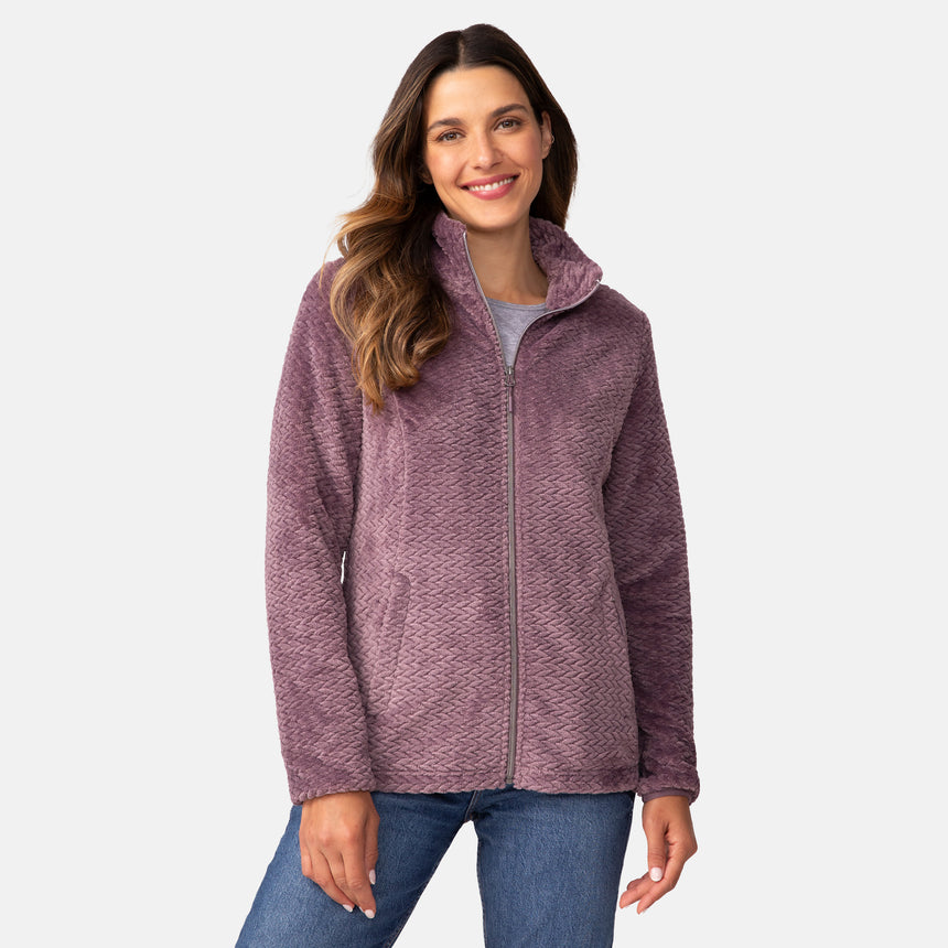 A woman wearing a mauve Women’s Cable Braided Butter Pile® Jacket over a grey t-shirt and blue jeans.