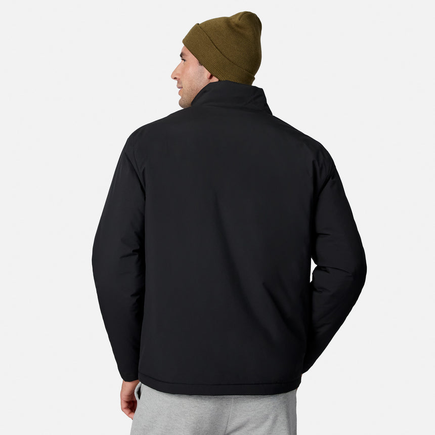 Back view of a man wearing a black Ace Puffer Jacket and an olive knit beanie.