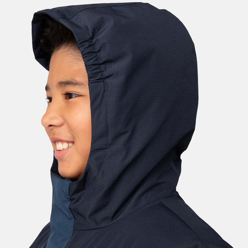 A smiling child in profile wears the Clearance Boys' Mount Avon Midweight Jacket, a dark navy, water-resistant kids’ coat with recycled insulation, set against a plain light background.