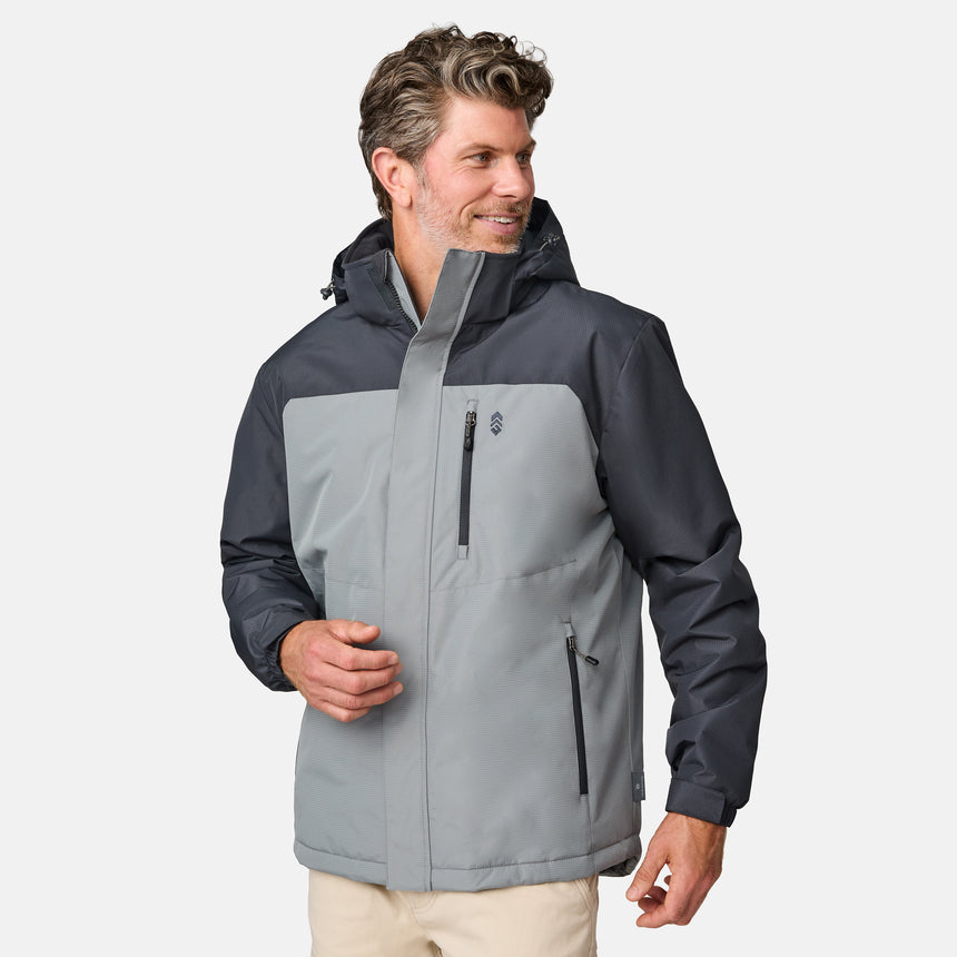 A man smiles to his right against a plain light background, wearing the Clearance Men's Arvon Insulated Jacket in two-toned gray and black, featuring water resistance, a high collar, and three zippered pockets.