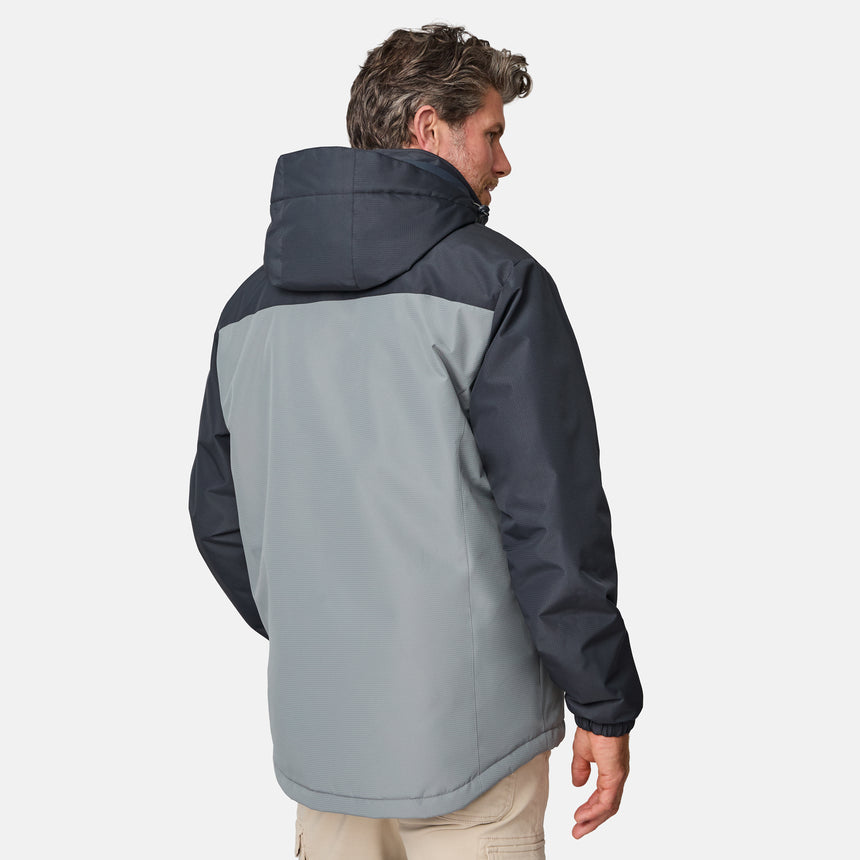 A man is seen from behind wearing the Clearance Men's Arvon Insulated Jacket with a dark upper section and light gray lower section, paired with beige pants, standing against a plain white background.