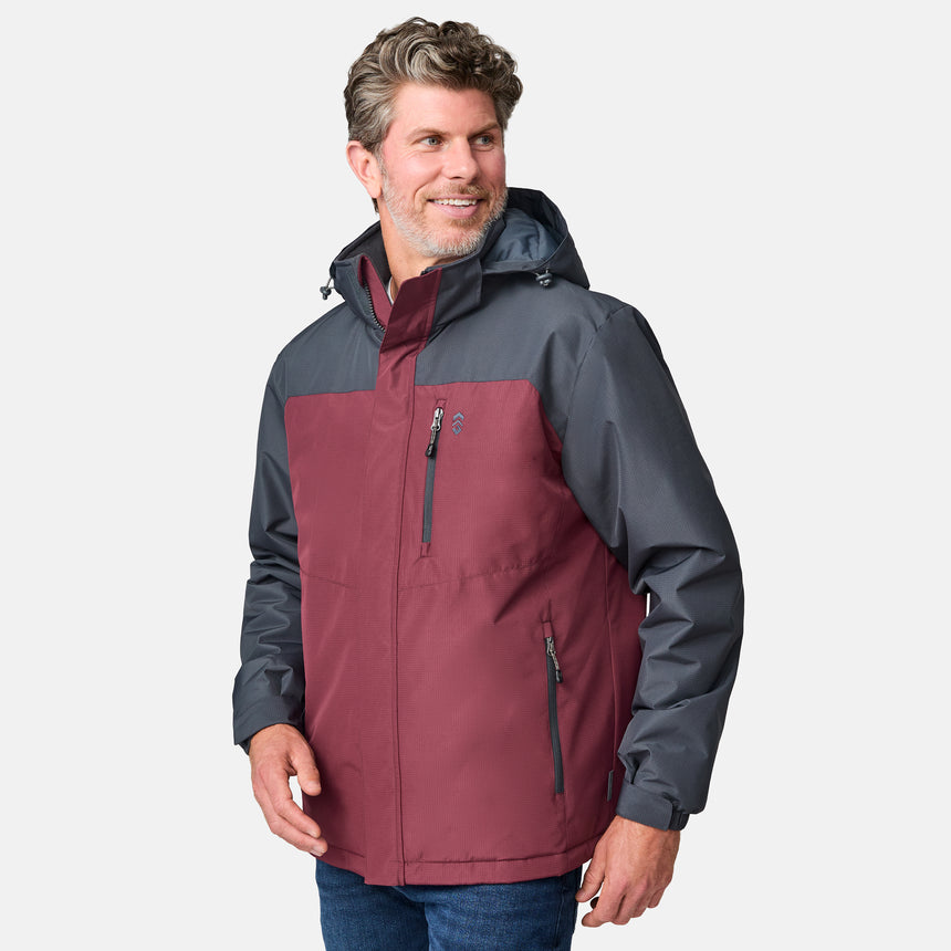 A man with light brown hair and a beard wears the Clearance Men's Arvon Insulated Jacket in maroon and dark gray, smiling as he looks to his left against a plain light background.