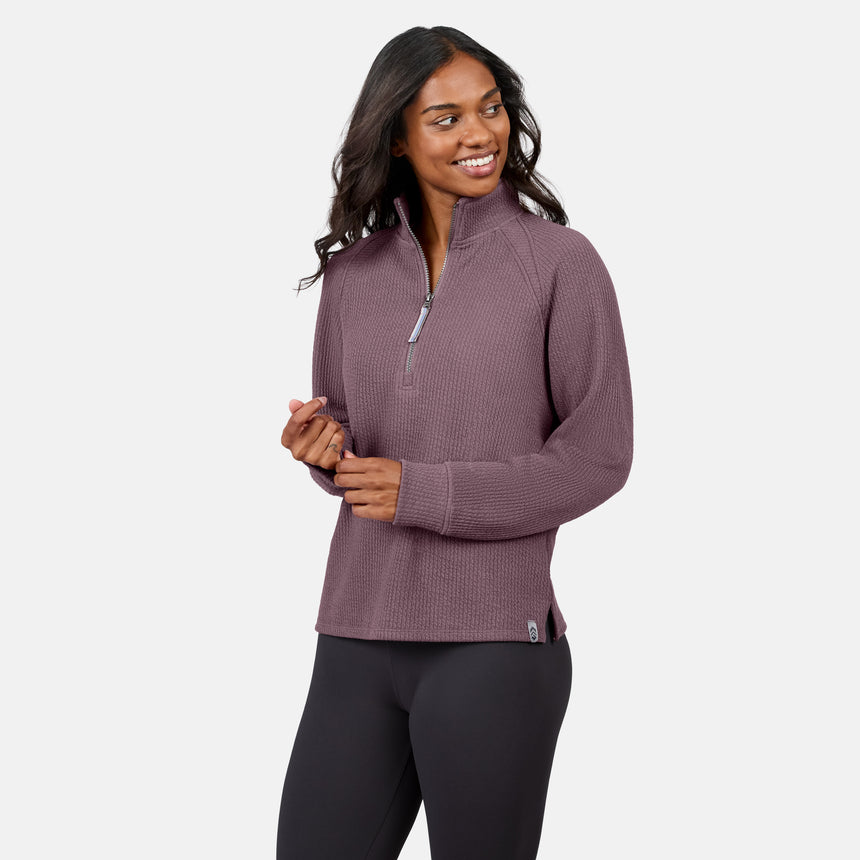 Woman wears the Free Country Women’s Ripple Knit Half Zip Top, light purple, paired with gray leggings and smiles against a plain white background—showcasing effortless casual style.
