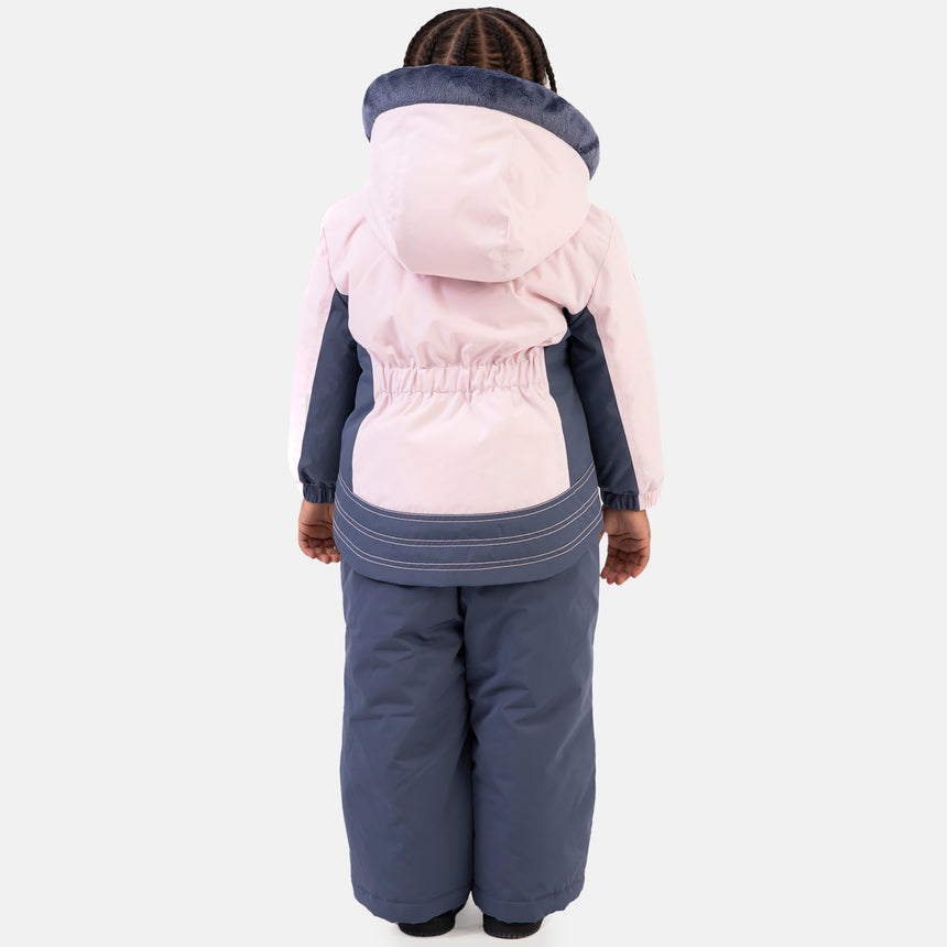 Young girl wearing the Free Country Girls' Toddler Boarder Jacket and Bib Pant Set, featuring a light pink and navy hooded jacket with Butter Pile® lining and matching navy snow pants, designed for winter play.