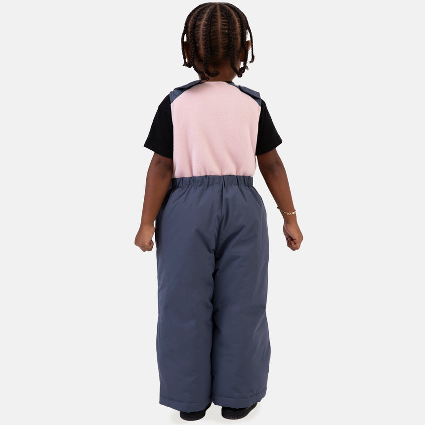 Young girl wearing the Free Country Girls' Toddler Boarder Jacket and Bib Pant Set, featuring a light pink and navy hooded jacket with Butter Pile® lining and matching navy snow pants, designed for winter play.