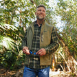 Man wearing Free Country Men's Stretch Rip Stop Adventure Vest in Putty, size M, made from wind resistant lightweight stretch polyester performance fabric featuring a convertible collar and full front zip closure #color_putty
