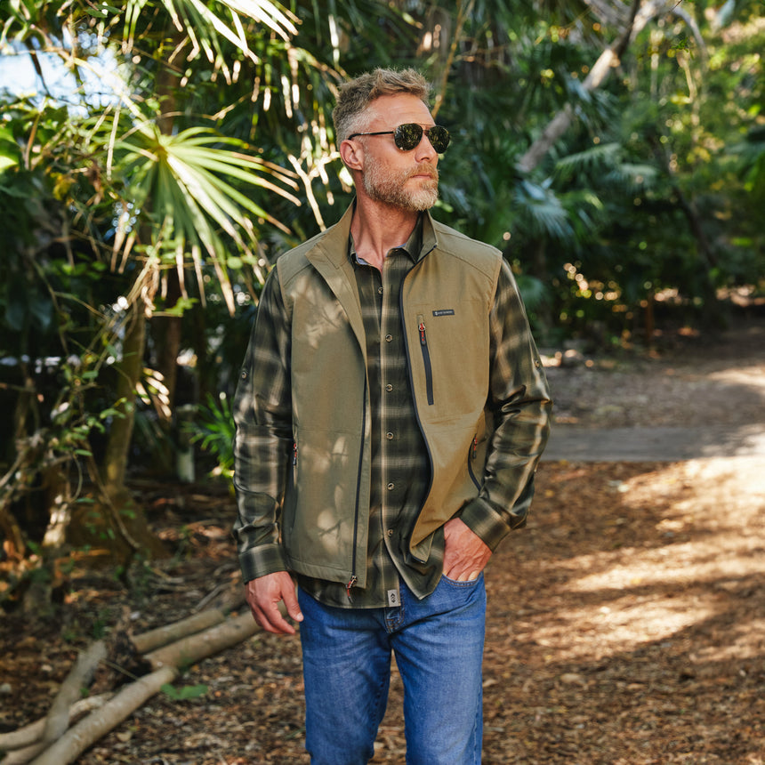Man wearing Free Country Men's Stretch Rip Stop Adventure Vest in Putty, size M, made from wind resistant lightweight stretch polyester performance fabric featuring a convertible collar and full front zip closure #color_putty