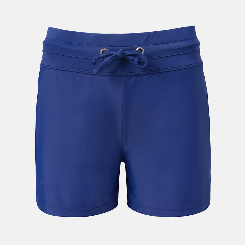 Free Country Women's Drawstring Swim Short in navy blue with a drawstring waist, small white logo on the lower left leg, and quick dry fabric, shown laid flat on a white background.
