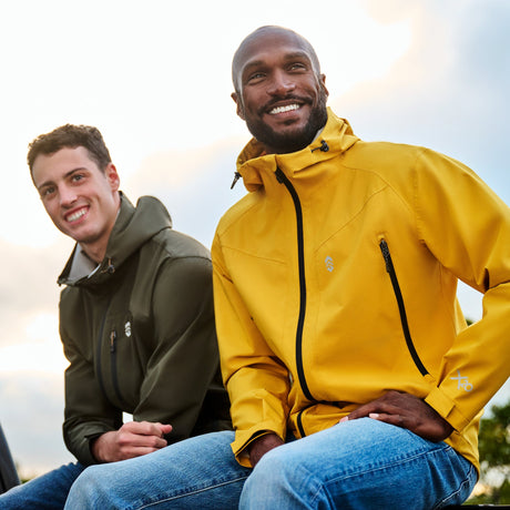 Two men in brightly colored Free Country Hydro Lite Rain Jackets stand in the rain.