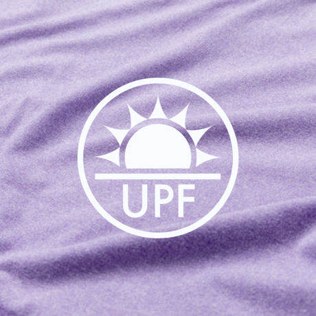 A close-up of light purple fabric with a white UPF symbol showing a sun above the letters UPF, indicating ultraviolet protection factor.