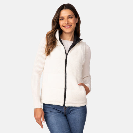 A woman smiles wearing the Clearance Women's Cascade Canvas 3-in-1 Systems Jacket over a long-sleeve top and blue jeans, with one hand in her pocket, standing against a plain light background.