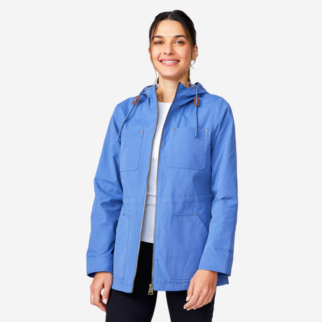 A woman smiles against a plain white background, wearing the Clearance Women's Lightweight Cascade Canvas Jacket in blue over a white shirt and black pants.