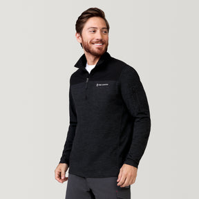 A bearded man wears the Men's Sueded Spacedye 1/2 Zip Colorblock Mock Neck Shirt by Clearance, smiling and looking to the side against a plain light gray background.