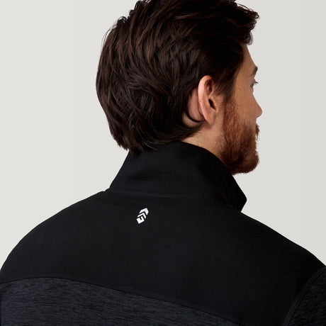 A man with brown hair and a beard is seen from behind, wearing the Clearance Men's Sueded Spacedye 1/2 Zip Colorblock Mock Neck Shirt in black, featuring a small white geometric logo on the back collar against a light gray background.