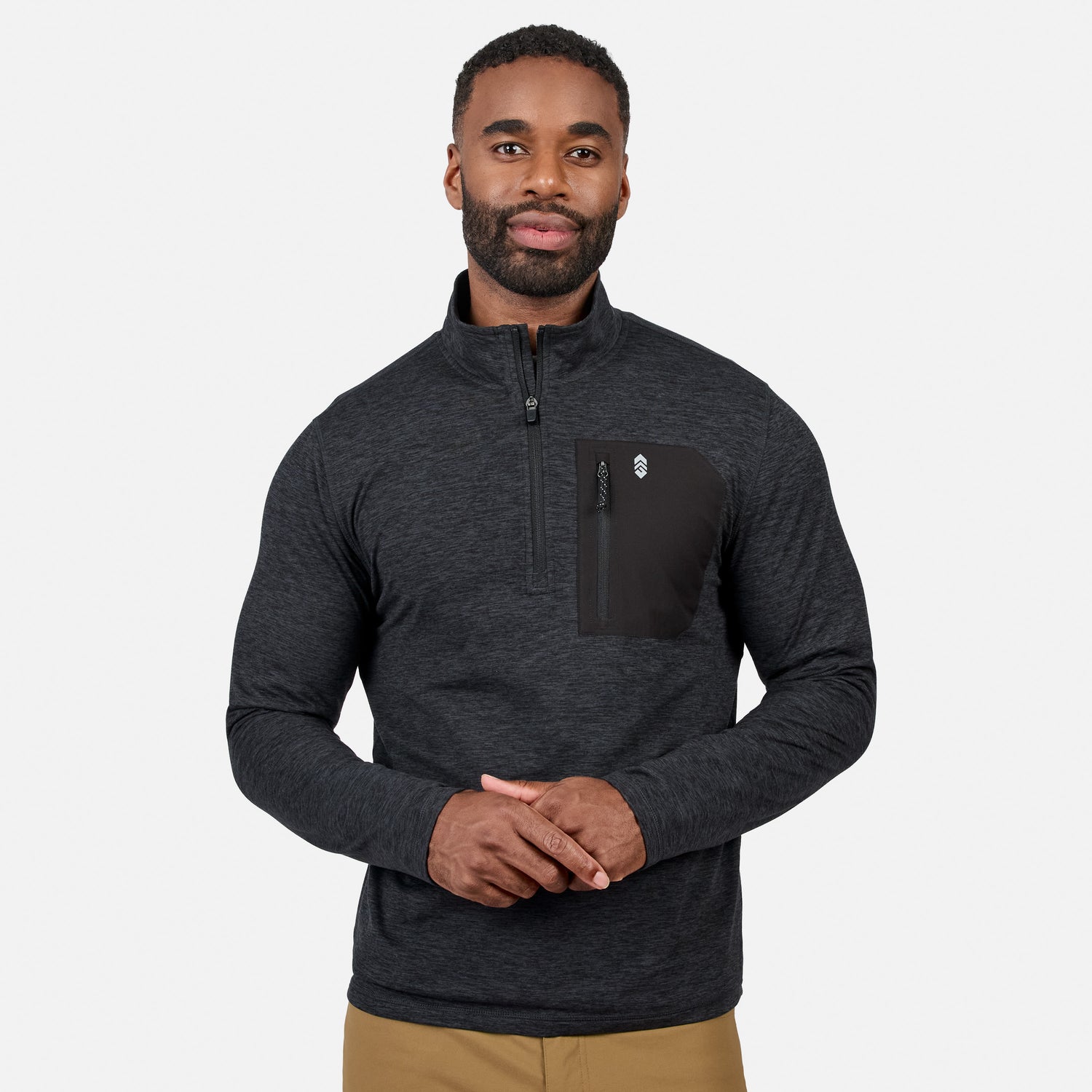 [Model is wearing size M.] A man wearing a dark heather gray quarter-zip pullover with a black chest pocket and zipper, paired with tan pants, against a light gray studio background.