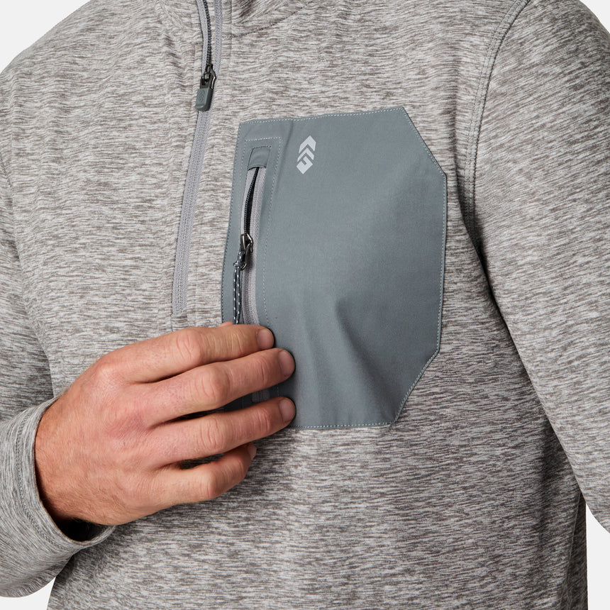 [Kolby is 6'2" wearing size M.] Men’s Free Country gray quarter-zip pullover with zippered chest pocket in contrasting fabric—paired with brown pants. Designed for lightweight layering, combining casual comfort and outdoor-ready functionality.