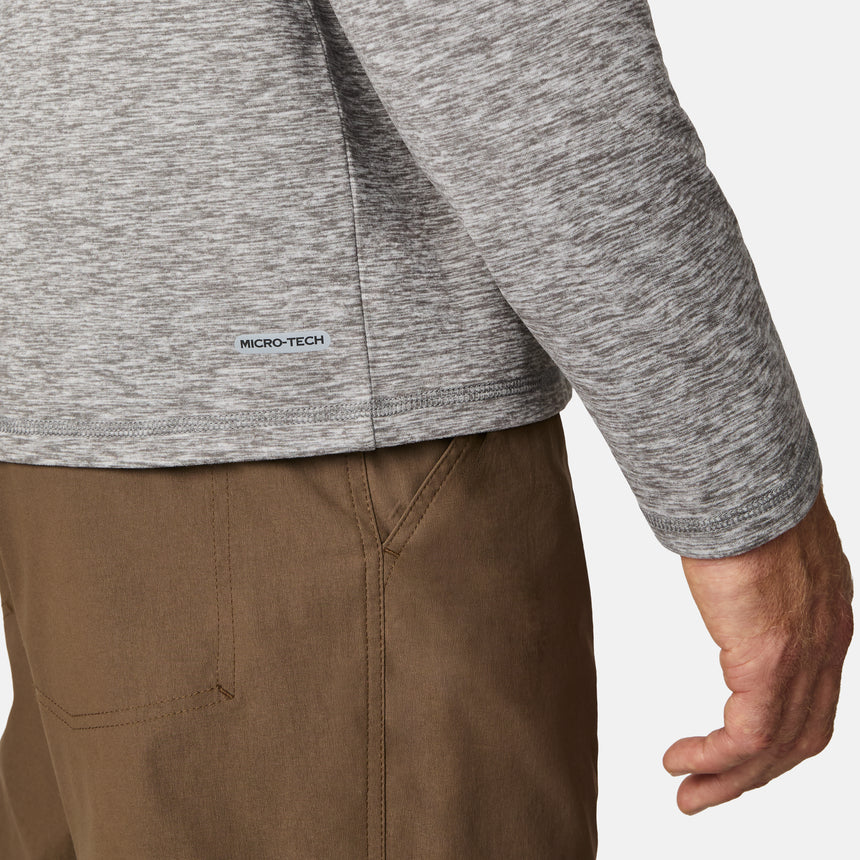 [Kolby is 6'2" wearing size M.] Men’s Free Country gray quarter-zip pullover with zippered chest pocket in contrasting fabric—paired with brown pants. Designed for lightweight layering, combining casual comfort and outdoor-ready functionality.
