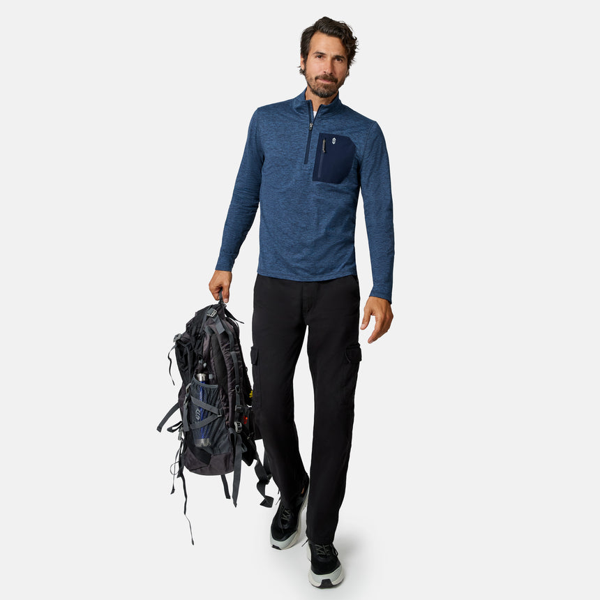 [Model is wearing size M.] A man wearing a heathered blue quarter-zip pullover, black cargo pants, and black sneakers is shown against a light gray background, holding a black hiking backpack.