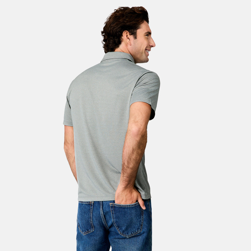 [Jacob is 6’1.5" wearing size M] Back view of man wearing a gray striped polo shirt and blue jeans on a white background