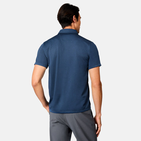 [Scott is 6’3" wearing size M] Back view of man wearing a blue polo shirt and gray pants on a white background