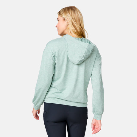 A woman with long blonde hair wears the Clearance Women's Cloud Knit Zip Hoodie in light green and black pants, standing with her back to the camera against a plain light background.