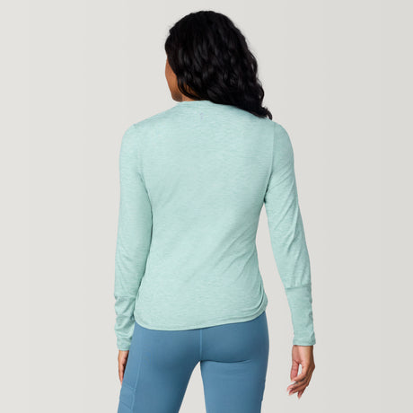 [Angelique is 5’10" wearing a size Small.] Woman wearing Free Country Women's Cloud Knit Crew Neck Top in Green Tea, size S, made from Breathable stretch performance fabric featuring a sueded finish and soft hand feel, styled with blue leggings