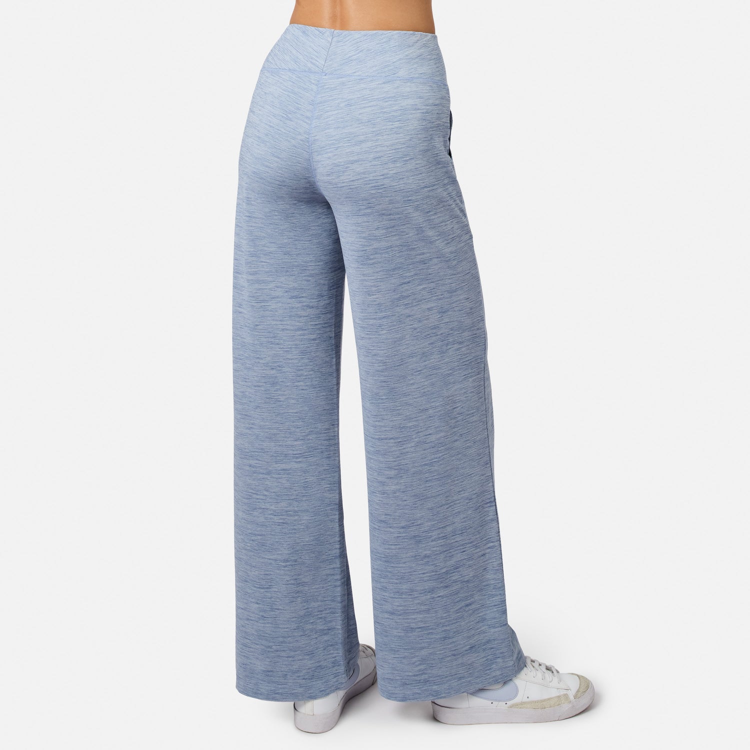 Person wearing Free Country Women’s Cloud Knit Wide Leg Pants in light blue with white sneakers, viewed from the back against a plain white background.
