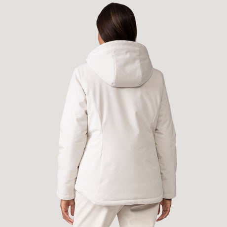 A woman with long brown hair, seen from behind, wears a Women's Thermo Super Softshell® Ski Jacket by Clearance in a light color with matching pants against a plain light gray background.