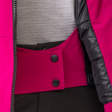 Close-up of a person wearing the Women's Thermo Super Softshell® Ski Jacket by Clearance in pink, featuring black snap buttons, black inner lining, and waistband detail. The jacket is partially unzipped over a gray shirt and black pants.