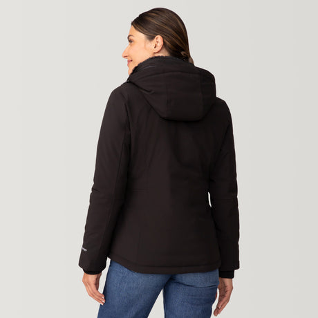 [Olga is 5’9" wearing a size Small.] Woman wearing Free Country Women's FreeCycle® Thermo Super Softshell® II Jacket in black with a full front zipper opening, lower pockets, soft lining, a detachable hood with an adjustable drawcord, and water resistant and wind resistant stretch performance fabric, light grey background. Best women’s jacket for winter weather.