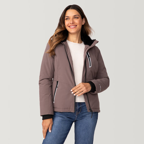 [Olga is 5’9" wearing a size Small.] Woman wearing Free Country Women's FreeCycle® Thermo Super Softshell® II Jacket in light brown with a full front zipper opening, lower pockets, soft lining, a detachable hood with an adjustable drawcord, and water resistant and wind resistant stretch performance fabric, light grey background. Best women’s jacket for winter weather.