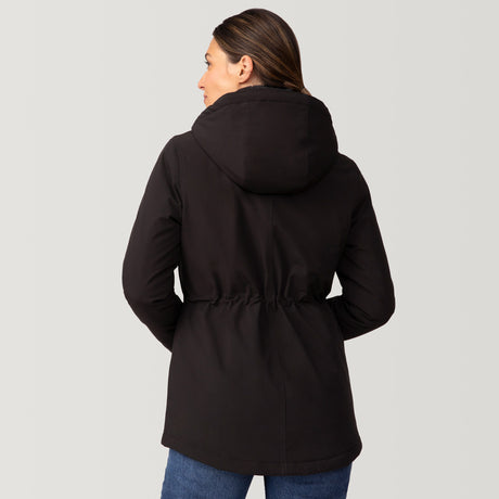 [Olga is 5’9" wearing a size Small.] Woman wearing Free Country Women's Thermo Super Softshell® Long Jacket in black with a full front zipper opening, lower pockets, diamond quilted lining, a hood with an adjustable drawcord, and water resistant and wind resistant stretch performance fabric, light grey background. Best women’s jacket for winter weather.