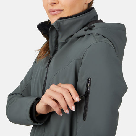 A woman, visible from the lower face down, unzips a small sleeve pocket on her gray Free Country Women's Thermo Super Softshell® Long Jacket with quilted lining. The background is plain white.